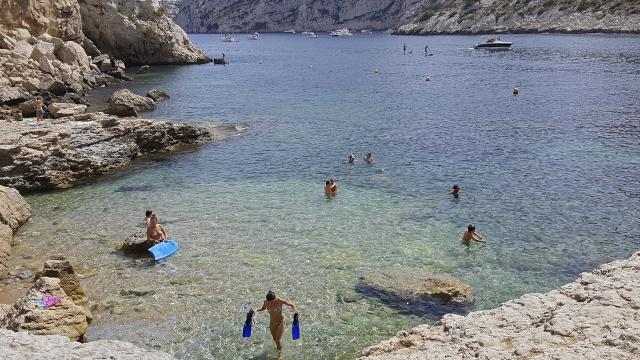 Baignade de plusieurs personnes dans l'eau turquoisedes Calanques de Marseille