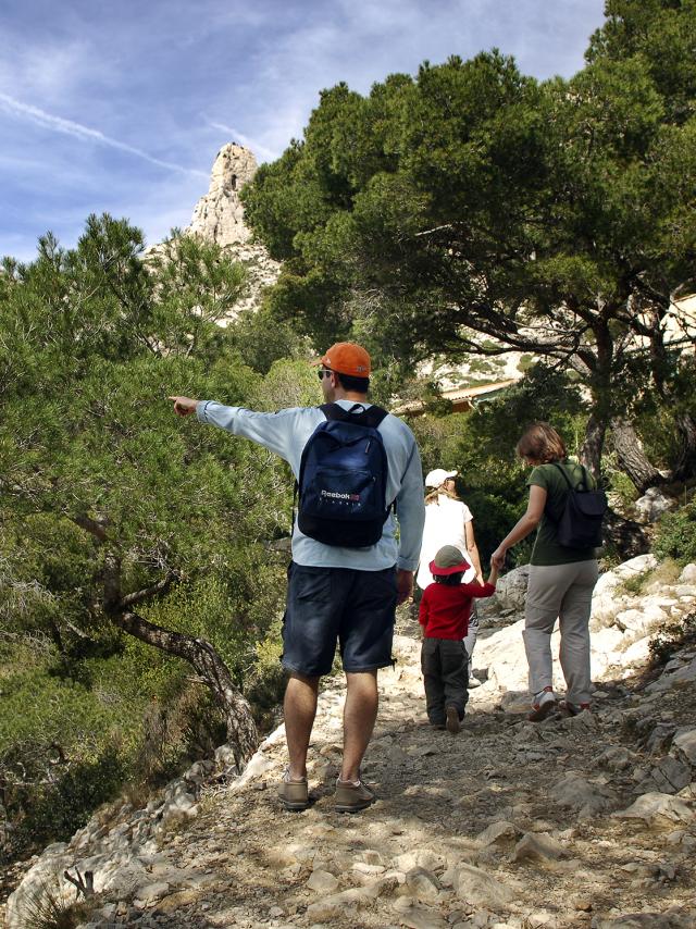 Promeneurs en famille sur le sentier des Calanques, entourés de pins