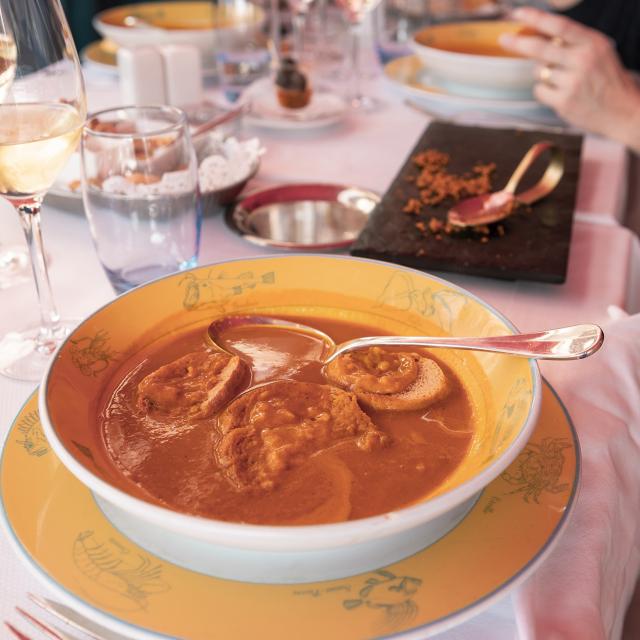 table de restaurant avec plat de soupe de poissons et crouton de rouille