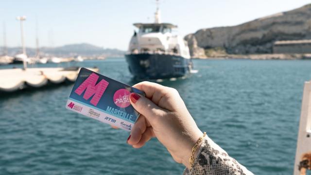 Femme tenant un citypass Marseille face à la mer
