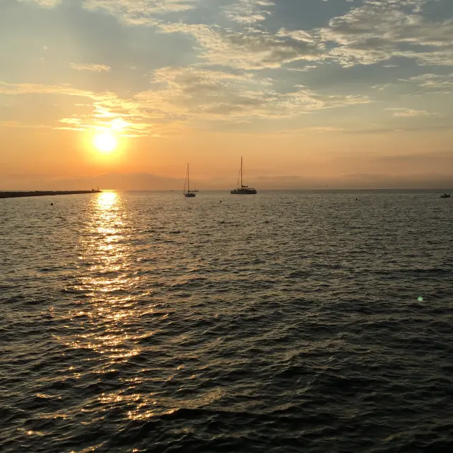Vista del mar y los barcos frente a la puesta de sol