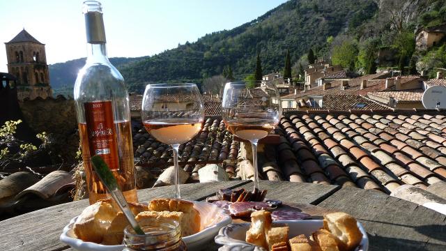 table apéritif, verre de rosé, pain et charcuterie, vue sur les toits et les colline
