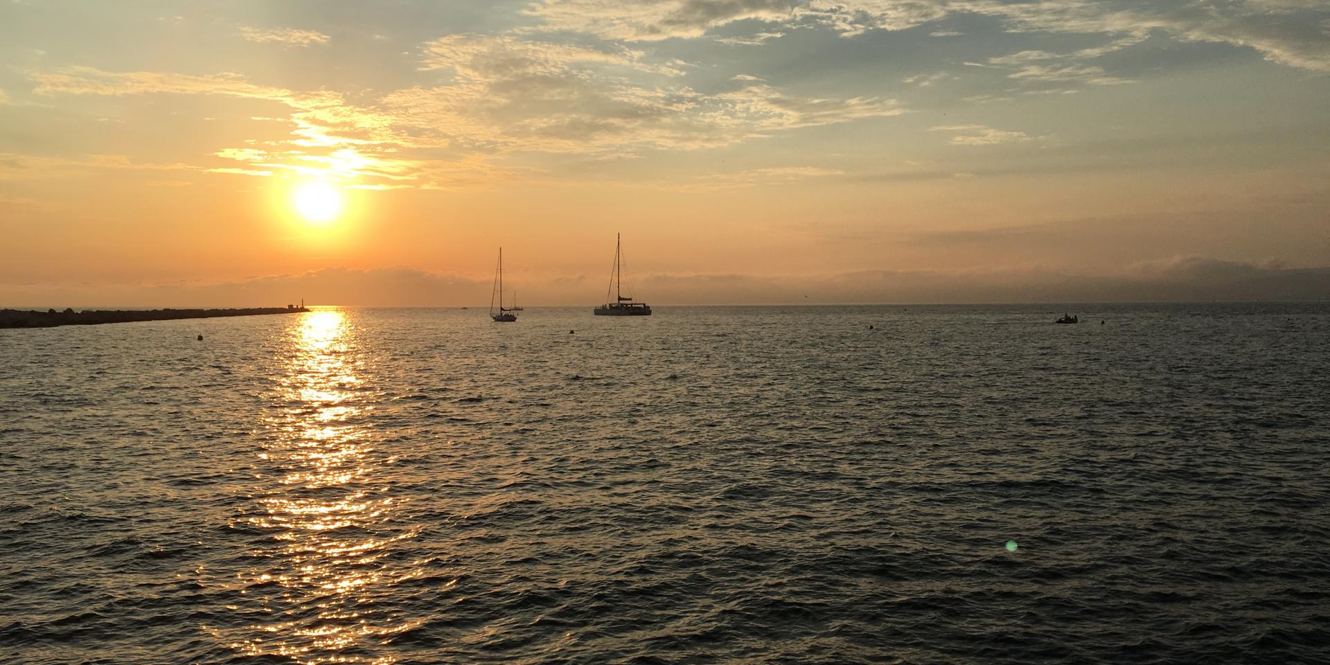 Vue sur la mer et les bateaux face au coucher de solei