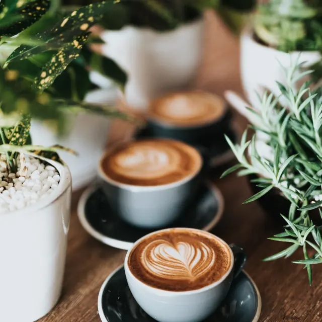Coffee cups with foam on a wooden table