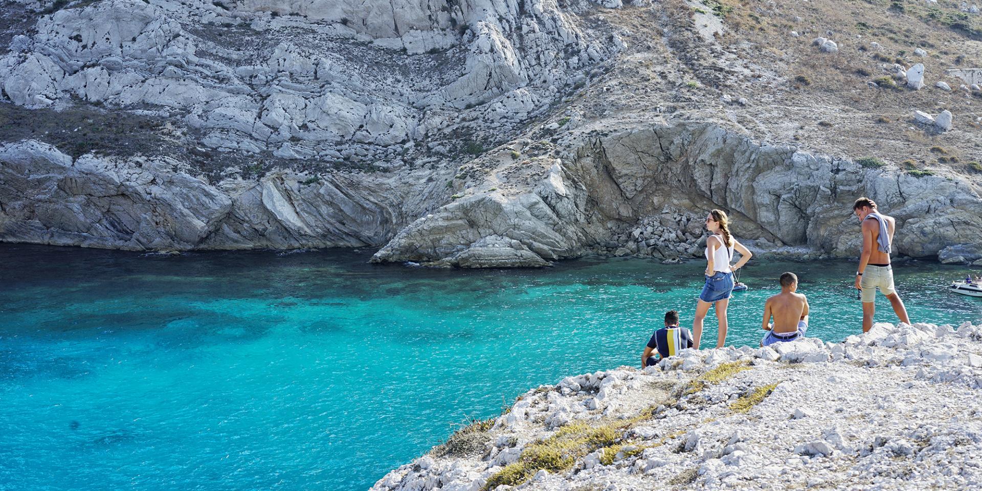 groupe d'amis sur les rochers aux Goudes en face de l'île Maire avec une eau turquoise