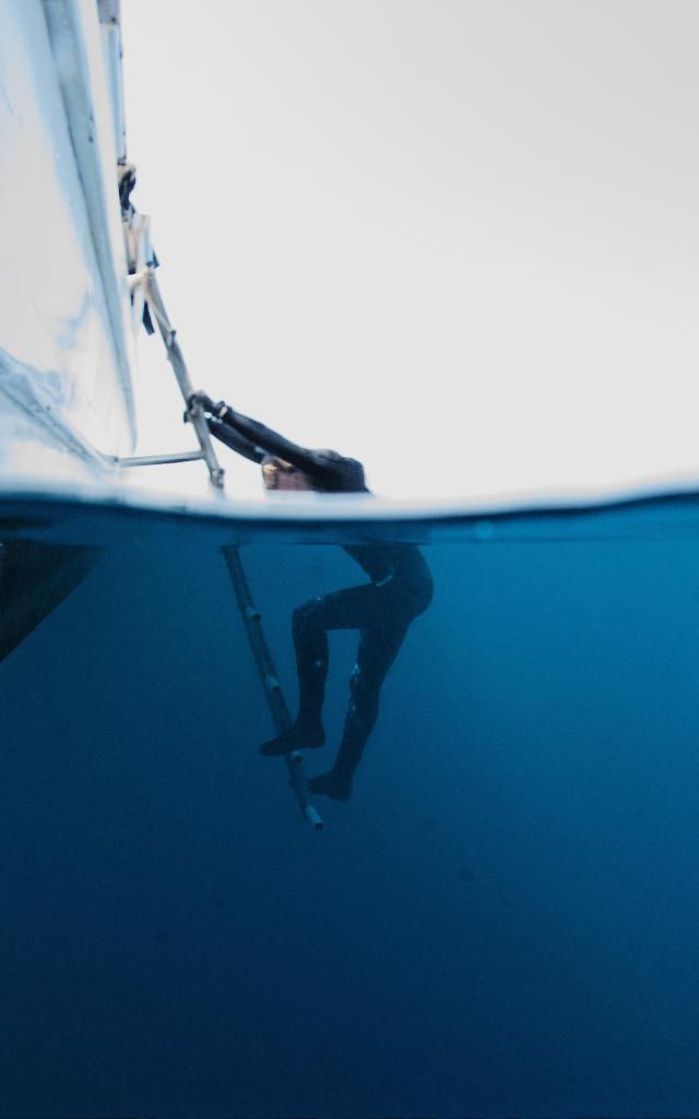 Plongeur qui remonte à bord d'un bateau