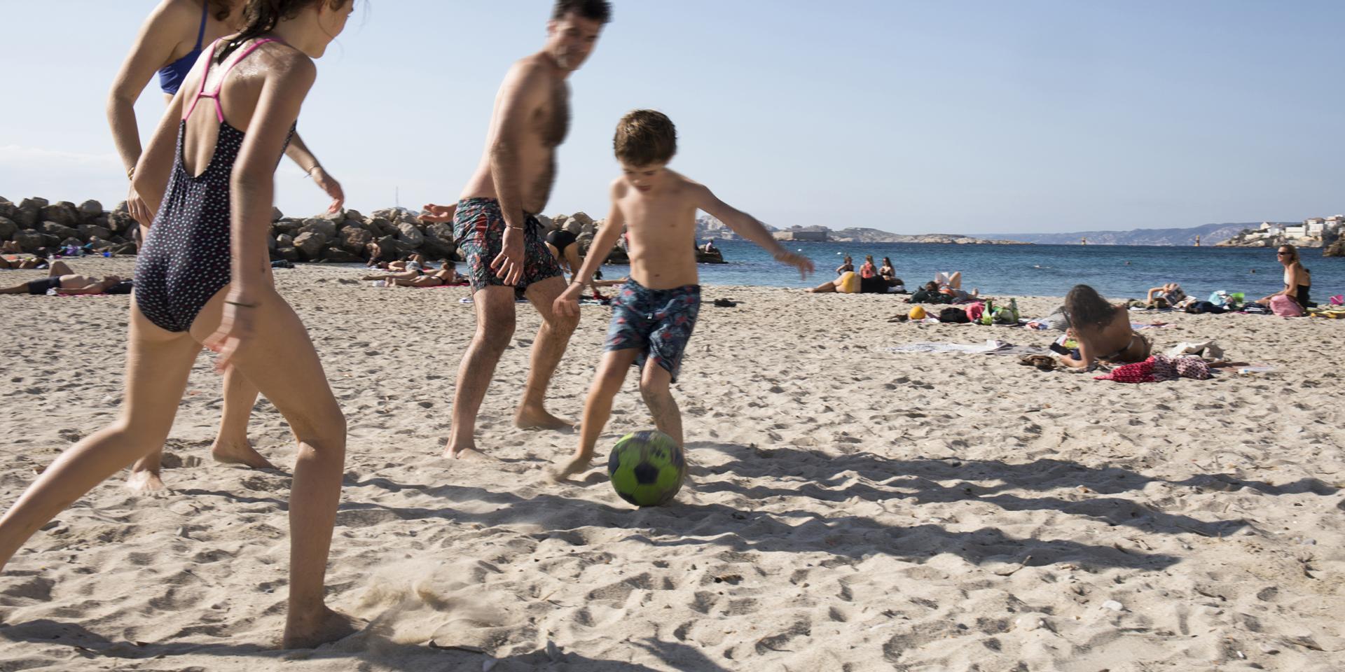famille qui joue au ballon sur la plage à Marseille