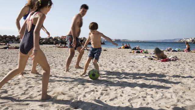 famille qui joue au ballon sur la plage à Marseille