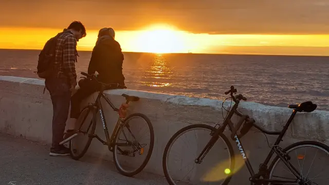 Couple with bicycles admiring the sunset on the Corniche Kennedy