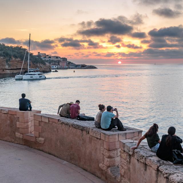 Groupe assis sur un muret au Fort StJean au coucher de soleil