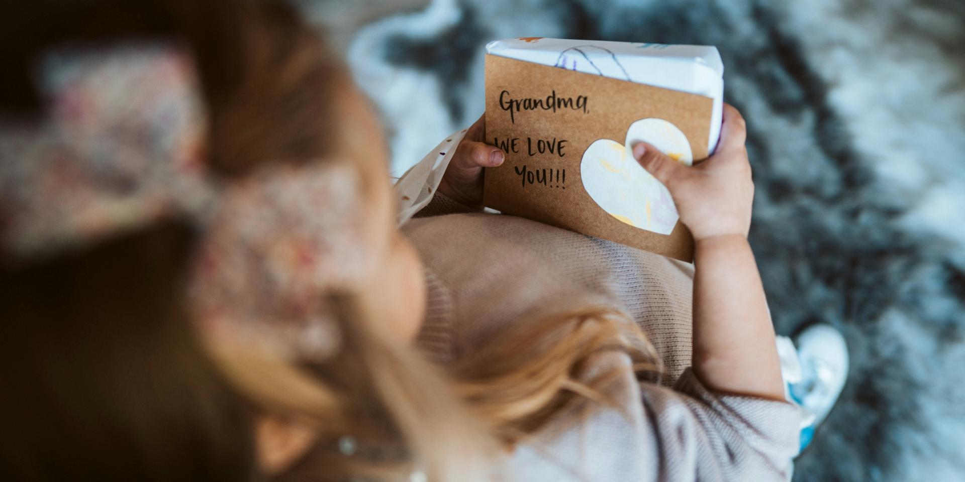 petite fille qui offre un cahier à sa grand mère