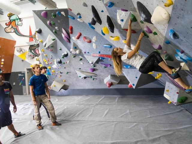 Personne qui escalade un mur dans une salle d'escalade