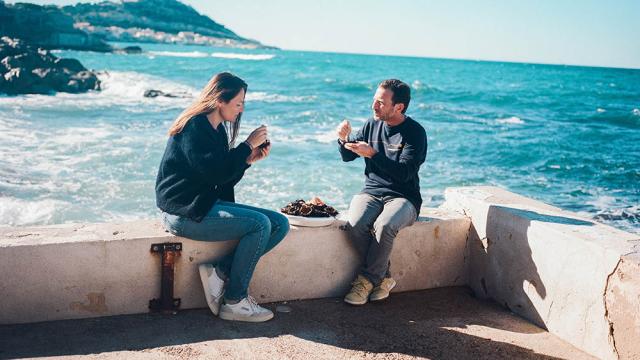un couple qui déguste un plateau d'oursins en bord de mer