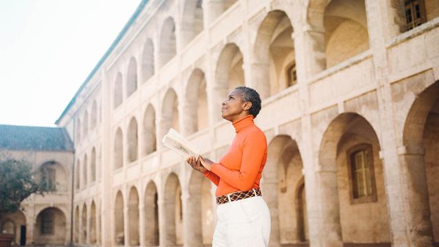 femme debout lisant un livre dans la cours de la vieille Charité à Marseille
