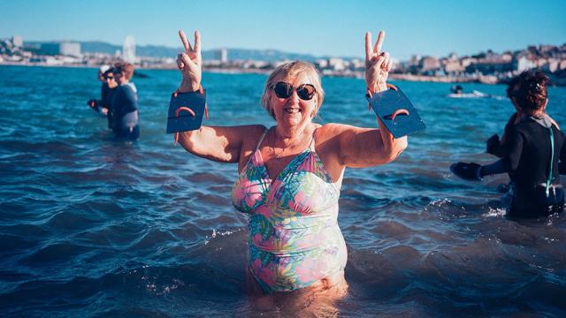femme souriante dans la mer, pratiquant le longe-côte